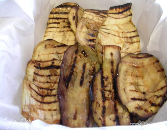 Моцареллу нарезаем ломтиками. Собираем нашу запеканку. Форму (лучше узкую прямоугольную для кекса) выстилаем пергаментом, выкладываем в нее слой баклажан.