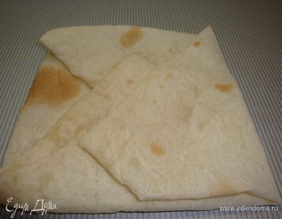 Лаваш нарезаем на квадраты, свернуть конвертиком и уложить в формы, выстланный бумагой для выпечки.