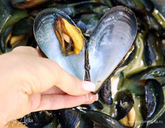 Почистить мидии. Промыть под проточной водой и резким движением удалить тину, которая выглядывает из каждой ракушки.
В большую сковороду влить оливковое масло, добавить 2-3 зубчика чеснока, раздавленных ножом и мидии. Влить вино, накрыть крышкой и оставить на большом огне минут 5, или пока мидии не раскроются.
Пропустить через сито жидкость, образовавшуюся при тепловой обработке мидий.
Влить в сковороду соус Наполетана.
Добавить  немного жидкости от мидий в томатный соус и  уварить пару минут (соус не должен быть слишком жидким). Мелко порубить петрушку и смешать с соусом. Посолить соус по вкусу и обильно поперчить.
В готовый соус добавить раскрытые мидии и потушить их в соусе минут 10.
Подать с поджаренным хлебом.
На терелки разложить хлеб и сверху выложить мидии.Хлеб должен пропитаться соусом. 