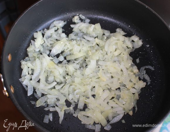 Лук измельчить, обжарить в 3 столовых ложках оливкового масла на среднем огне 5 минут. Затем добавить 2 измельченных зубчика чеснока. 