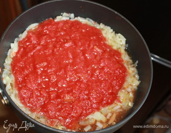 Через пару минут положить томаты в собственном соку, соус с оливками и томатами, сушеный базилик и готовить 6-8 минут.  