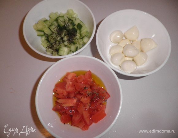 Огурцы, моцареллу и помидоры нарезаем на кубики. Овощи заправляем оливковым маслом и добавляем базилик, желательно свежий. 
