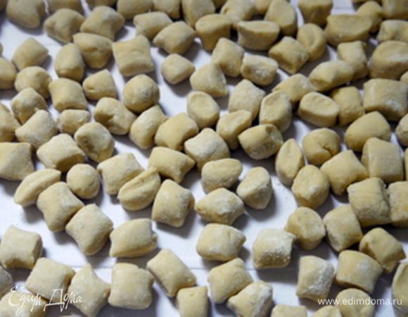 Через час достать тесто и сформировать ньокки, предваритель сделав жгуты из теста и нарезав их на кусочки. Ньокки должны быть примерно 2х2 см размером.