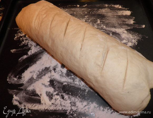 Сворачиваем в виде рулета.  Выкладываем на противень, смазанный маслом . Сверху острым ножом делаем надрезы и даем снова подойти (где-то около 30-40 минут). 
