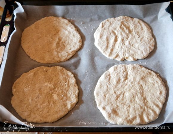 Поднявшееся тесто разделить на 10 одинаковых частей.

Раскатать  8 частей в лепёшечки по 1/5 см толщиной (Скалкой пользоваться не обязательно.Тесто хорошо формируется руками). Перенести 4 лепёшки на противень, накрытый бумагой для выпечки.