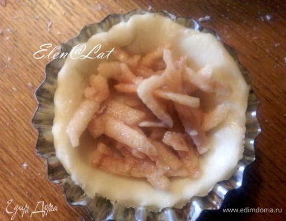 Каждый шарик раскатать в лепешечки диаметром 7 см.
 Каждый круг смазать растопленным сливочным маслом, и уложить в формочки для кексов, а затем уложить по чайной ложечки яблока натертого или мелко нарезанного. 