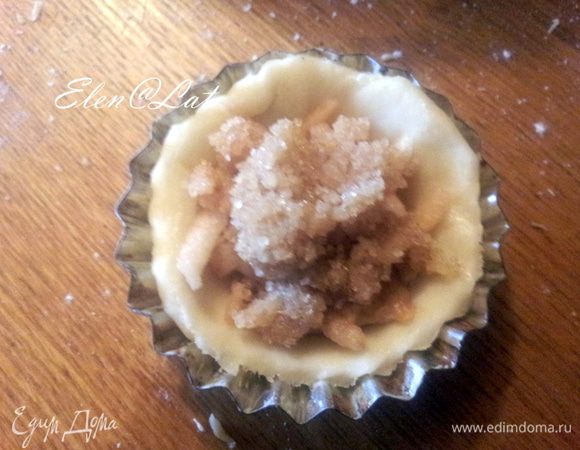 На яблочко выложить по 1 чайной ложки сахарной массы. Края лепешки завернуть наверх, но не до конца, в центре печенье  должно быть открыто, как у беляшей, кончики теста прищипать.