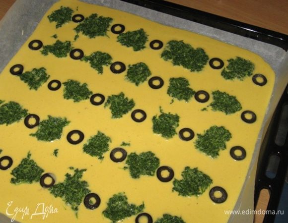 Берем противень, выстилаем его кулинарной бумагой и хорошенько натираем сливочным маслом. Омлет выливаем на противень, разравниваем и украшаем: аккуратно выкладываем рядочками кашицу из зелени, а между ними - кружки маслин и убираем в духовку на 10 минут при 200 градусах.