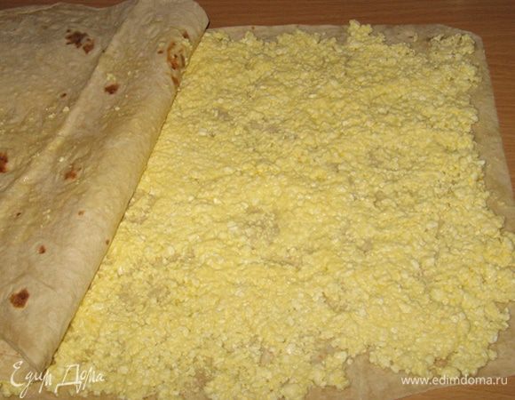 На один лист лаваша равномерно распределить творожную начинку. Сверху накрыть вторым листом и начинаем сворачивать рулет.