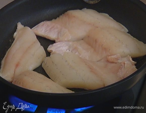 Разогреть в сковороде со съемной ручкой растительное масло и обжарить рыбу с одной стороны. Когда верхняя сторона рыбы посветлеет, отправить сковороду в разогретую духовку на 7–8 минут.