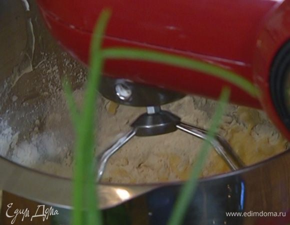 Не выключая комбайна, порциями всыпать муку с разрыхлителем и 140 г сахара.