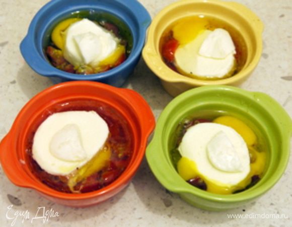 Приготовить 4 креманки. Смазать дно оливковым маслом. Мелко порубить помидоры.Выложить на дно креманок порубленные помидоры.Или, что гораздо вкуснее, влить немного соуса Наполетана от Saclà (примерно 1 см).
Разбить в каждую креманку по яйцу. Посолить, поперчить. Присыпать орегано, тимьяном и базиликом.
Сверху положить по кружочку моцареллы.Запечь в духовке на водяной бане (поместив в ёмкость с кипящей водой) при 200° около 7 минут. Подать с жареным хлебом.