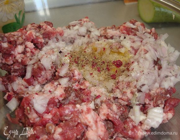 Лук очистить и измельчить. 1 зубчика чеснока пропустить через пресс. Лук и чеснок смешать с говяжьим фаршем, сливками, яичным желтком. Посолить и поперчить по вкусу. 