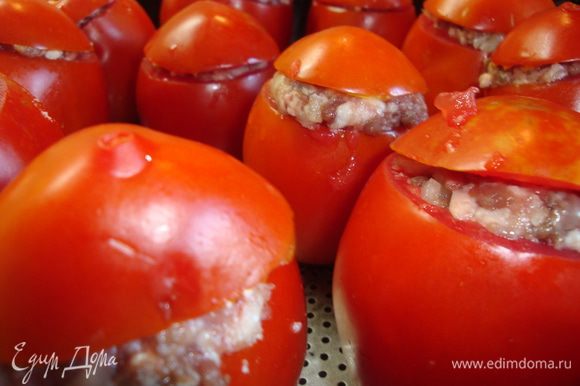 Нафаршировать помидоры, прикрыть крышечками и переложить в форму для запекания.
