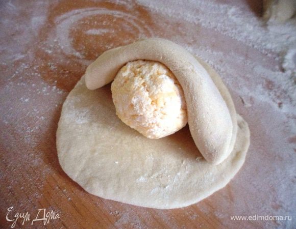 Каждый кусочек немного раскатать и положить на него творожно-сырный шарик и накрыть вторым раскатанным кусочком теста.
