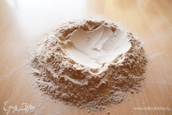 Муку, какао, соль просеять на стол. Сделать в центре углубление (ямку).