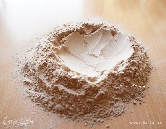 Муку, какао, соль просеять на стол. Сделать в центре углубление (ямку).