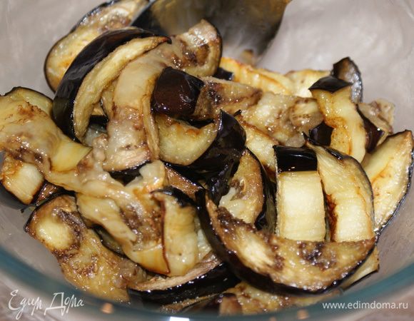 Духовку разогреть до 18 градусов. Запекать баклажаны 15-20 минут. Готовые баклажаны выложить в миску и полить оливковым маслом. Хорошо перемешать.