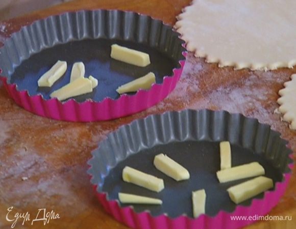 Сливочное масло нарезать кусочками и разложить в две формы. 