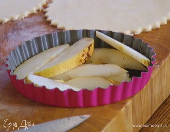 Груши, удалив сердцевину, нарезать небольшими кусочками и выложить поверх масла. 