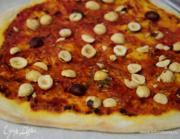Достать пиццу (духовку не выключать), выложить на нее половинки орехов и сыр двух видов. Поставить запекаться на 5 минут.