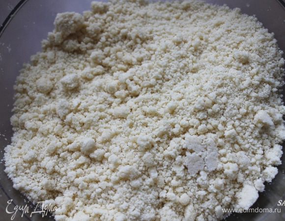 Приготовим песочное тесто. Этот процесс должен происходить как можно быстрее, тогда тесто будет рассыпчатым и нежным.
Горкой просеиваем муку в глубокую чашку или на разделочную доску. Делаем углубление, вливаем растительное масло (либо смалец), кладём маленькими кусочками сливочное масло. Оно должно быть не слишком холодным (чтобы в руках давилось), но и не растекающимся. Солим.
Кончиками пальцев быстро смешиваем муку и масло в крошку.
