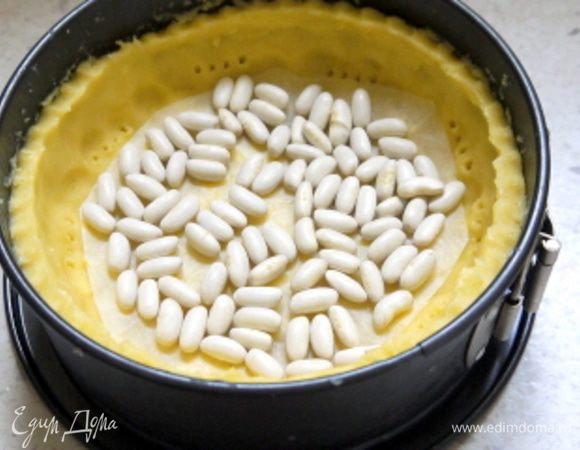 Для теста порезать  холодное масло на крупные кусочки.Перемешать в комбаине муку с холодным порезанным маслом.Добавить в комбайн яйцо, сахар, цедру лимона и щепотку соли.
Комбайн должен работать, пока масса не соберётся в шар.
Достать готовое тесто, завернуть в целофан и убрать в холодильник на 30 минут.

Достать из холодильника песочное тесто и раскатать его на пергаменте в пласт толщиной около 5 мм. Перенести тесто в форму ( у меня 18 см в диаметре) вместе с пергаментом. Наколоть вилкой, накрыть другим листом пергамента и насыпать слой сухого гороха или фасоли. Выпекать при 180° около 20 минут.