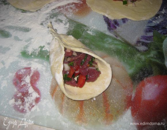 На тесто кладем хорошую порцию начинки и защипываем треугольником края .