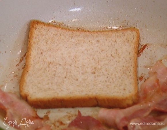 Выложить к бекону хлеб и обжарить его с двух сторон.