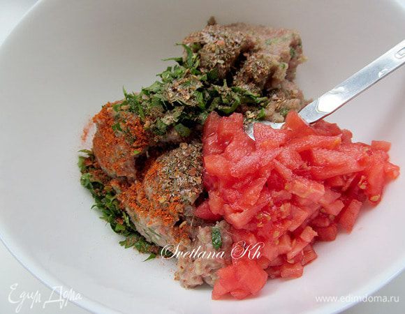 Мясо измолоть в блендере, мясорубке или мелко посечь ножом вручную.
Добавить лук, зелень, помидоры, специи, соль. Влить немного минеральной воды и хорошо размешать.
