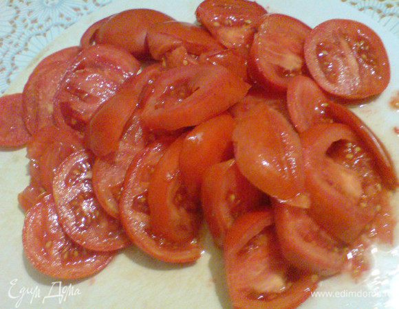 Духовку разогреть до 200 градусов. Сыр натереть. Оставить 1/3, а остальной смешать со сметаной. Помидоры нарезать кружочками.