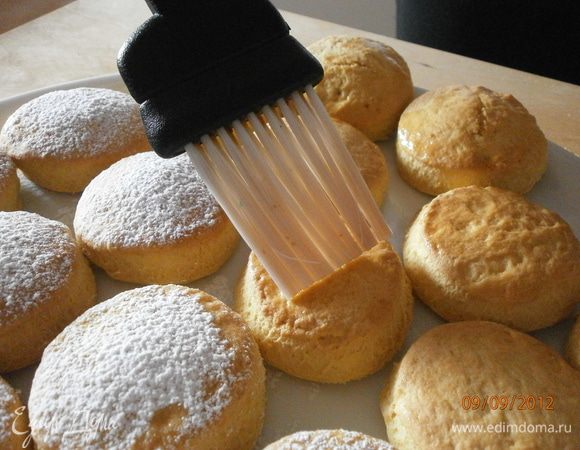 Ещё горячее печенье смазать сахарным сиропом и посыпать сахарной пудрой.