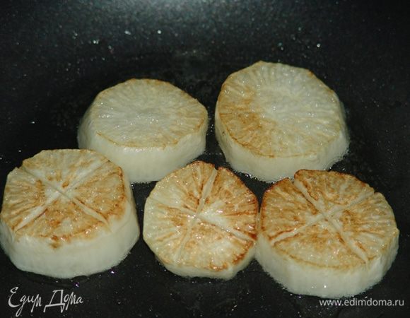 Обжарить дайкон на кунжутном масле до появления корочки. Русскоязычный интернет советует для жарки добавлять чеснок. Иностранные сайты такого не рекомендуют. 