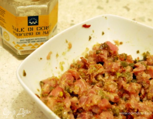 Перенести рыбу в ёмкость, добавить фисташки, каперсы и помидоры. Заправить лимонным соусом и перемешать.Посолить по вкусу.
