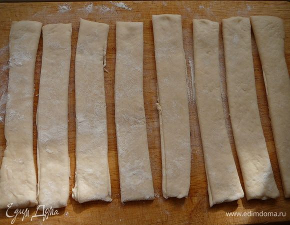 Готовое дрожжевое тесто порезать на полоски шириной 2 см.