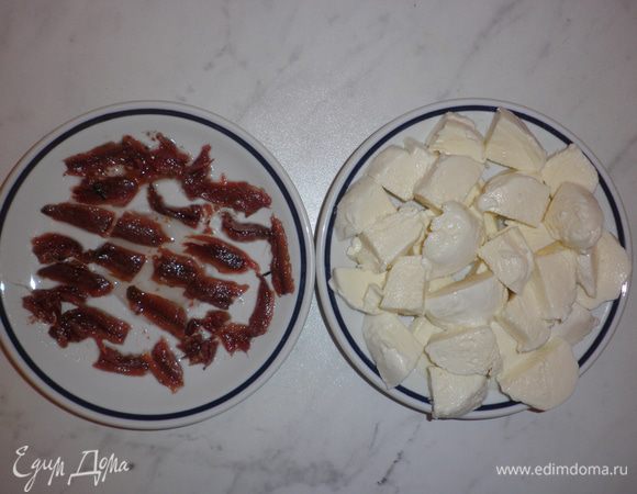 Из баночки с анчоусами (alici) слить масло и нарезать филе рыбки на небольшие кусочки.
Также нарезать шарики моцареллы на небольшие кусочки. Я всегда беру больше моцареллы, чем подразумевает рецепт, так как в процессе готовки часть её обязательно съедается...