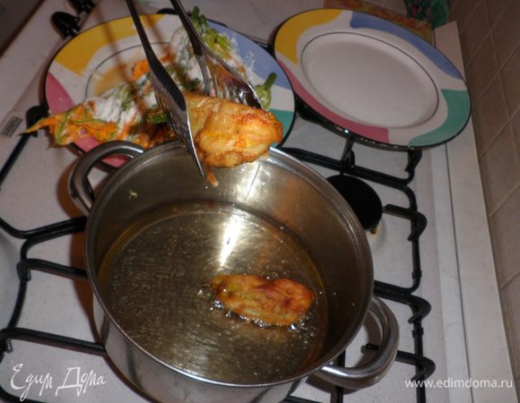 В кастрюльке или глубокой сковороде хорошо разогреть масло для фритюра (слой масла должен быть 3-4 см, чтобы цветочки в нем "плавали").
Подготовленные нафаршированные  цветки цукини окунуть в кляр и затем, сразу же поместить в раскаленное масло.Обжарить со всех сторон до золотистого цвета и выложить на бумажное полотенце, чтобы удалить излишки жира.