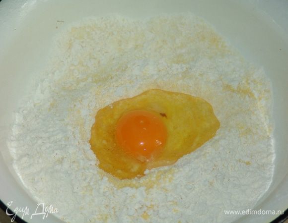 Замесить домашнее тесто.  Для того, чтобы лапша получилась желтая, используем смесь муки из твердых сортов пшеницы и кукурузную (в пропорции 2:1). В муку разбиваем яйцо, добавляем щепотку соли. Муки - сколько тесто попросит (примерно стакан). Лапши получается больше, чем необходимо для супа. 