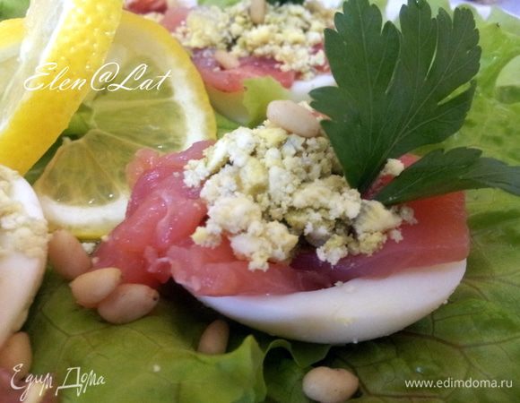 Сверху выложить раскрошенный желток, украсить петрушкой, посыпать кедровыми орешками и сервировать дольками лимона и листьями салата. Все закуска готова. Приятного аппетита!