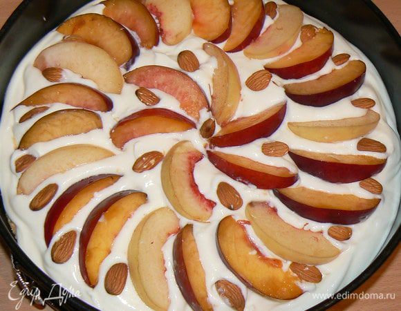 Сверху разложить дольки персиков и посыпать орехами. Поставить персиковый пирог в духовку на 45-50 минут при 170 градусах