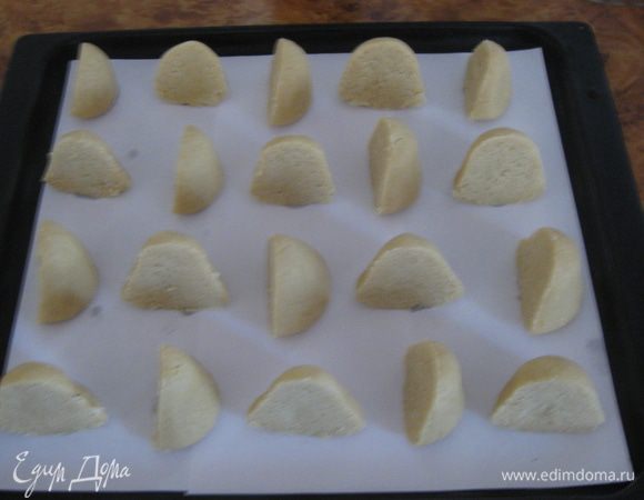 Слепить комок теста, положить на открытую ладонь и накрыть другой ладонью. Скатать конус (сильно не давить, рассыпется). Разрезать ножом пополам. Разрезанные половинки выложить на противень.