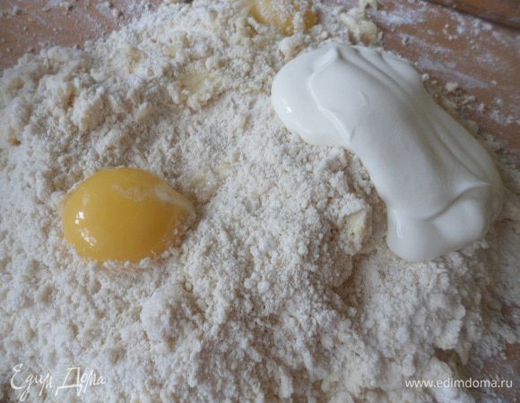 Добавить яйца, сметану, соду и замесить тесто