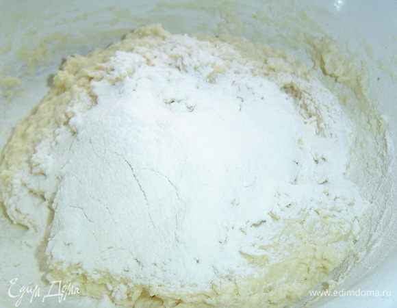 Постепенно добавляем просеянную муку с содой и замешиваем тесто.