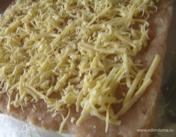 Выложить полученный фарш на лист фольги, равномерно распределить слоем толщиной не больше 1 см. Посыпать по всей поверхности тертым сыром,