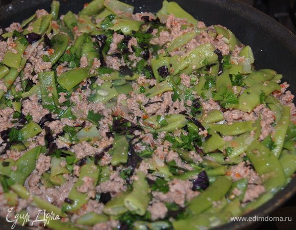 На сковороду налить немного растительного масла. Обжарить на нем лук, добавляем фарш и тоже обжариваем. Помидоры протереть через терку добавить к фаршу. Солим, перчим. Добавляем фасоль тушим вместе с мясом еще 5мин. В конце посыпаем разной рубленной зеленью.