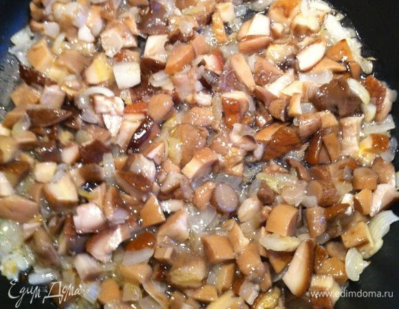 Добавьте мелко нарезанные белые грибы и тушите 15–20 минут. Влейте вино и тушите еще 5 минут.