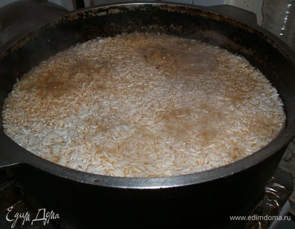  чуть не забыла, для любителей чеснока. 2-3 головки хорошего  чеснока почистить ( снять верную шелуху, но чтоб при этом все зубчики оставались так же собраны в кучку. Поэтому повторю, только верную, и слегка почистить донышко,  или как правильно назвать то на чем держатся все зубчики  Таким образом подготовленный чеснок выкладываем на зирвак .
Слить воду с риса и выложить равным слоем на морковь, и потихоньку налить воды чтоб слегка покрыть рис ( колличество воды зависит от того, насколько рис любит воду)  и ждем когда выпарится вода.