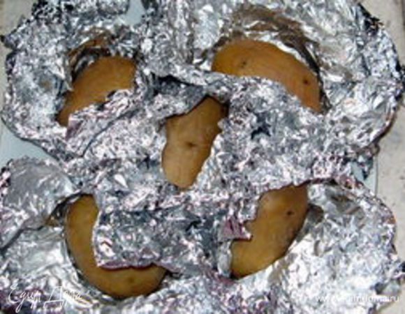 Завернуть нечищенный картофель по одному в фольгу и запечь в духовке. Время зависит о размера клубней.В среднем, около 30 минут при 220° C.