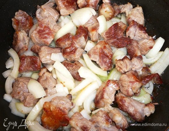 Баранину обжарить на оливковом масле до образования корочки. Добавить лук и жарить еще 5 минут.