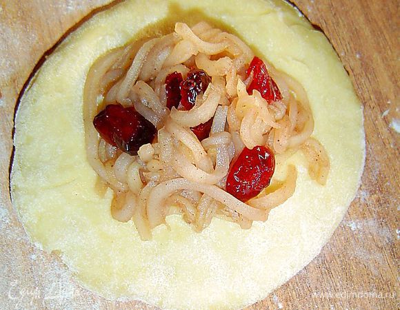 Разъемную форму диаметром 26-28 см закрываем пергаментной бумагой «HomeQueen», а бока формы смазываем маслом. От теста отрываем кусочек величиной с куриное яйцо, разминаем на листе пергамента в лепешку, а в центр кладем десертную ложку начинки.